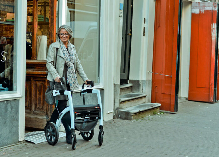Dame, die in Amsterdam mit Rollator geht