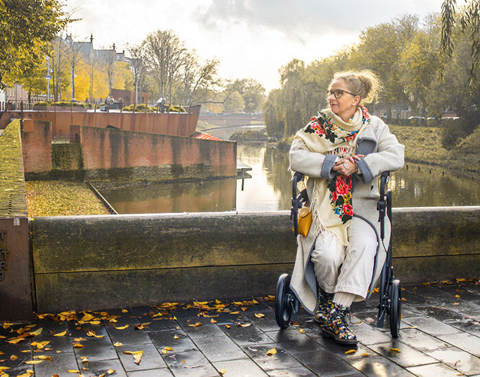 Frau sitzt auf einem Rollator mit korrekter Position