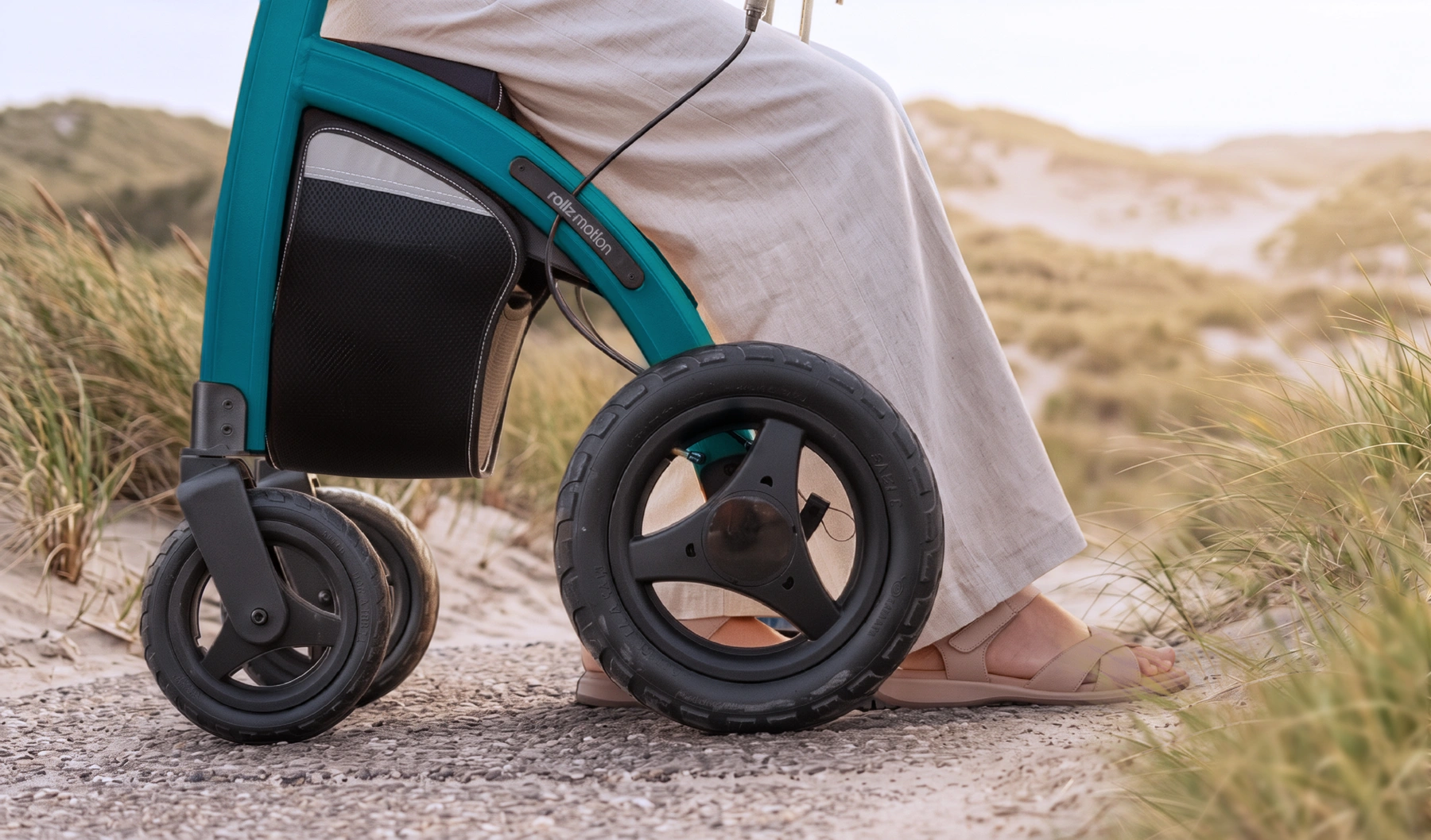 A person sitting on a jungle green Rollz Motion Performance in the dunes